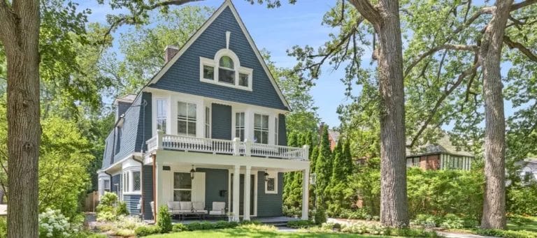 Blue House with Porch Surrounded by Trees