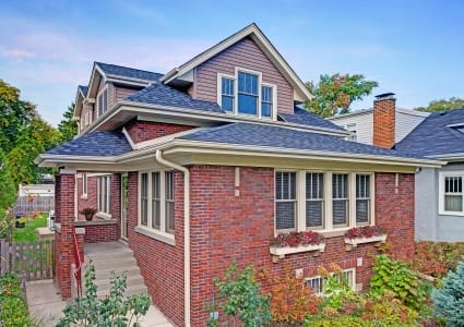 Traditional Red Brick Bungalow with Sloping Second Story and Dormers