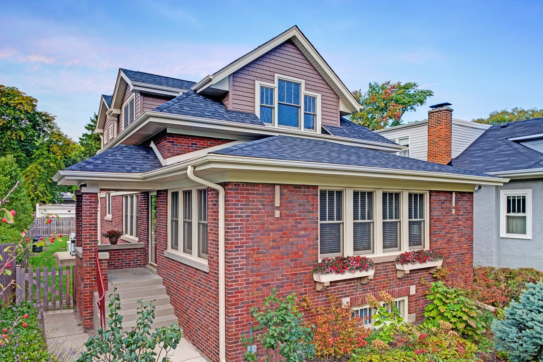 Traditional Red Brick Bungalow with Sloping Second Story and Dormers